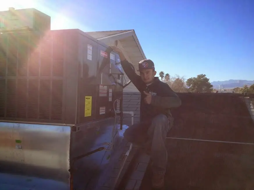 HVAC technician performing Boiler Repair on a rooftop unit in Oak Hills